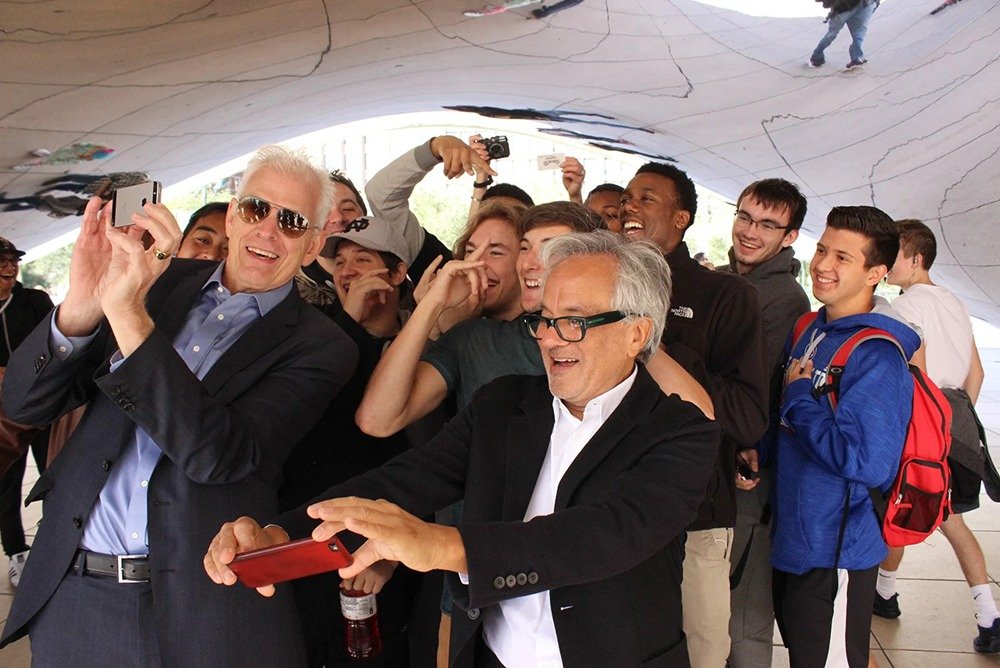 Artist Anish Kapoor and others posing with the Bean sculpture