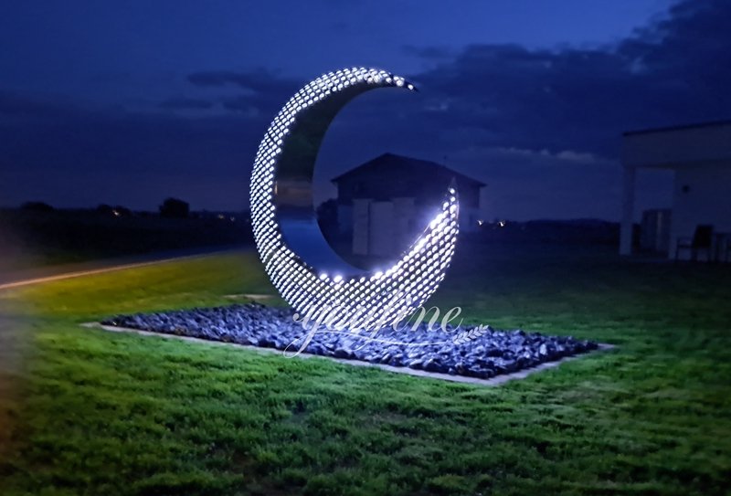 German stainless steel half moon sculpture feedback at night